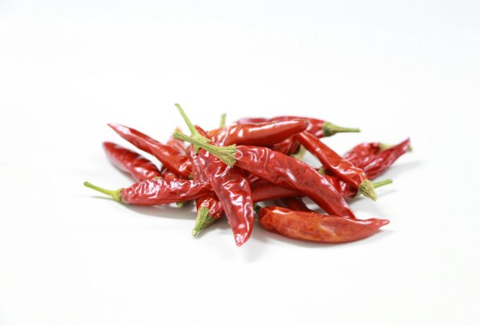 A vibrant collection of red chili peppers arranged on a white background, showcasing their fiery color.